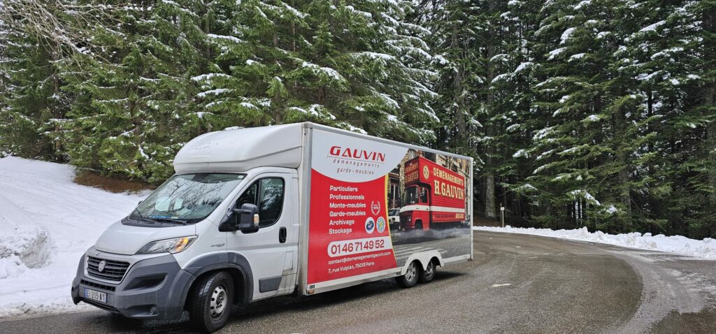 Vue rapprochée d'une échelle monte-meuble télescopique atteignant une fenêtre de bureau dans un immeuble en pierre de taille.