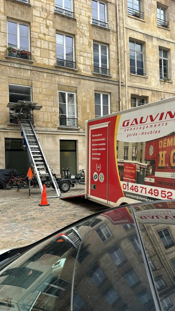 Monte-meuble autoporté installé dans une cour pavée à Paris pour un déménagement avec un camion Gauvin Déménagements.