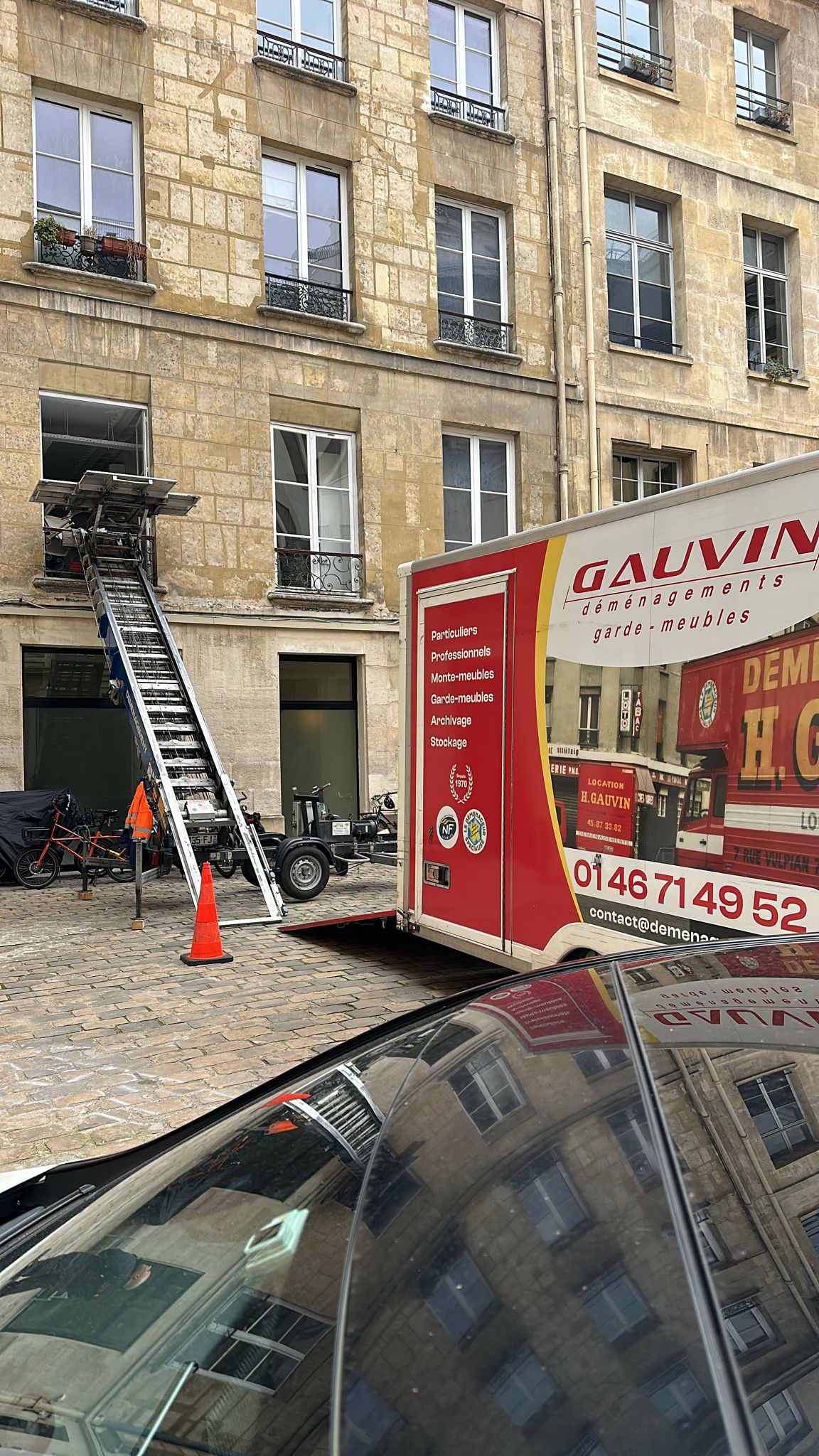 Monte-meuble autoporté installé dans une cour pavée à Paris pour un déménagement avec un camion Gauvin Déménagements.