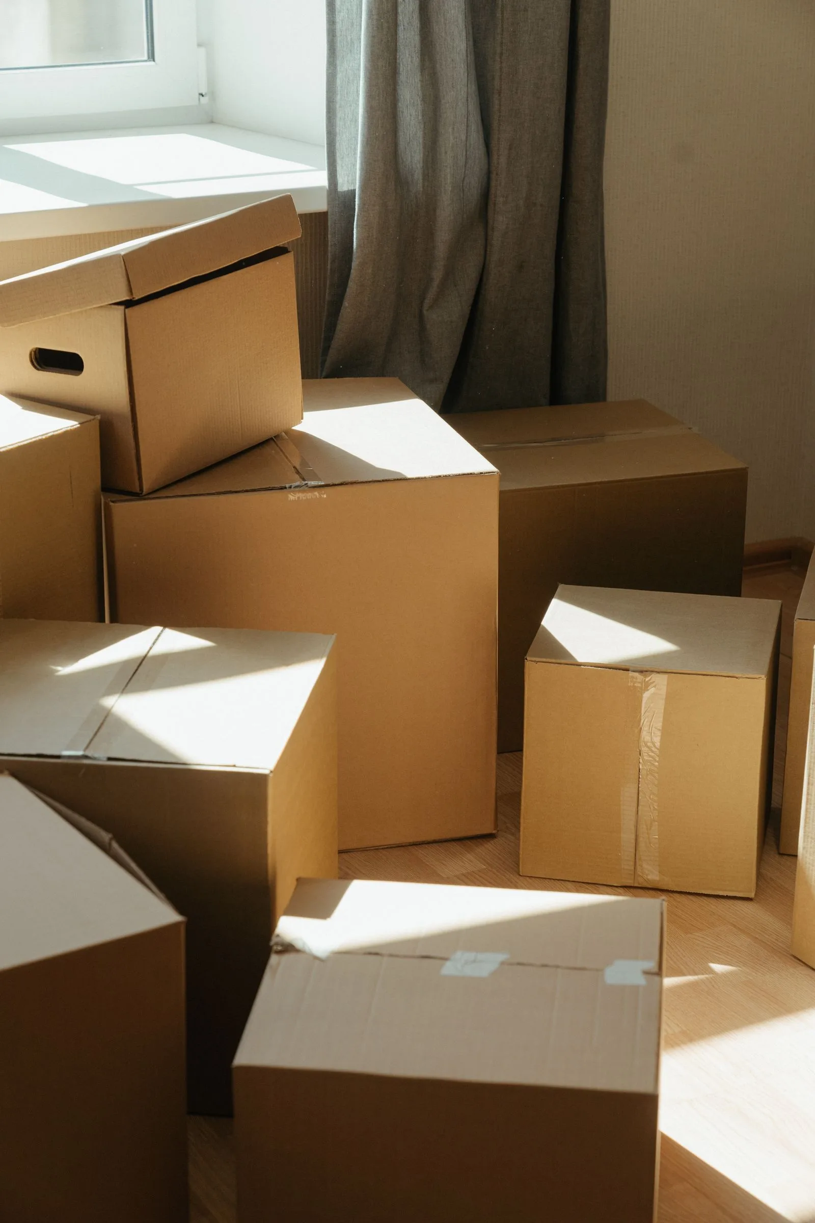 Cartons de déménagement kraft empilés dans le salon avant le départ
