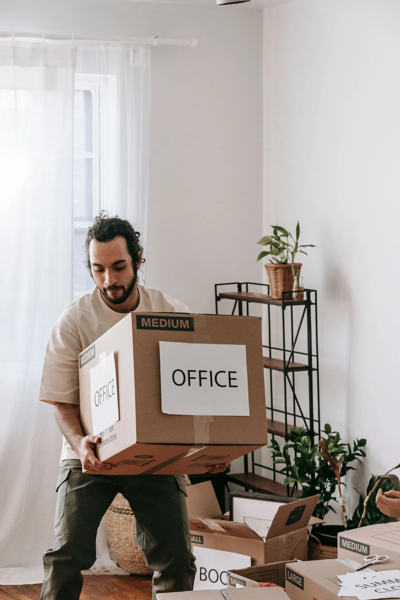 Déménageur portant une pile de cartons de bureaux